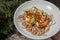 Udon and prawn spicy salad served on white plate