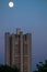 Uenusually large moon over the skyscraper in a summer evening sky.