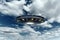 UFO, an alien plate soars in the sky, hovering motionless in the air. Unidentified flying object, alien invasion, extraterrestrial