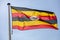 Uganda flag waving against clear blue sky