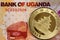 Ugandan 1000 shilling bank note with gold Chinese coin
