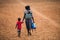 Ugandan mother with her baby on back and her son