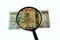 Ugandan shillings bill and magnifying glass