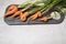 Ugly deformed carrot roots on a wooden cutting Board, light background.