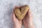 Ugly or deformed potato in the shape of a heart in the hands of a little girl. No food waste. Trendy ugly vegetables, ecological