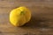 Ugly double organic lemon unusual shape turned its back on wooden textured surface with knife. Buying imperfect product