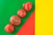 Ugly food concept, deformed tomatoes on the red, green and yellow background, copy space, creative geometric image