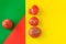 Ugly food concept, deformed tomatoes on the red, green and yellow background, copy space, creative geometric image