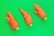 Ugly food. Deformed organic carrots on pastel background in green and orange duoton