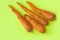 Ugly food. Deformed organic carrots on the pastel yellow background. Bright colors, copy space