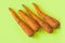 Ugly food. Deformed organic carrots on the pastel yellow background. Bright colors, copy space