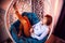 Ugly girl in a white shirt and red jeans on a white wicker hanging chair