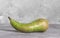 Ugly green pear on gray background concept