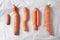 Ugly misshapen carrots on craft paper background. Concept of zero waste production. Top view. Copy space. Non gmo vegetables