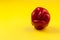 Ugly red bell pepper on yellow background with copy space. Concept - reduction of food organic waste. A deformed crooked vegetable