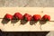 Ugly strawberry on a wooden pine bar with harsh shadows from the daytime sun. New harvest. Country style
