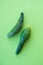 Ugly vegetables, deformed cucumber on a trending green pastel background