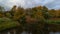 UHD 4k Time Lapse movie of dark moving clouds over pond water reflection with fall autumn colors in Crystal Springs Garden 4096x23