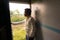 Ujjain- m.p.- india- a boy is standing at the front of the door of a train