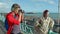 UK, Brighton. Young guy taking photo of hipster girl on the coast. Happy lovers, woman and man traveling on vacation on