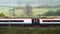 Uk railroad next to rapeseed field and sheep on another side under overcast rain. railway landscape