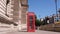 UK red phone box on the London Central Streets. Red British Phone Booth, London background.