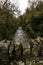 UK river in autumn fall with top of dry stone wall of bridge in foreground