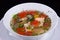 Ukha - fish soup with salmon slices, shrimp and mussels with red bell pepper