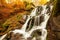 Ukpaine. Waterfall among the mossy rocks. Beautiful landscape rapids on a mountains river in autumn forest in carpathian