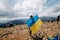 UKRAINE - August 24. 2019. Patriot woman stands with national Ukrainian flag and waving it praying for peace at top of Hoverla