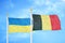 Ukraine and Belgium two flags on flagpoles and blue sky