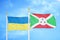 Ukraine and Burundi two flags on flagpoles and blue sky