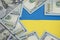 Ukraine flag and one hundred dollars around. Money concept chart growing US dollar position