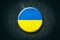 Ukraine flag. Round badge, on a dark background. Signs and Symbols