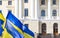 Ukraine independence concept blue and yellow flags on government main building background exterior facade with entrance door