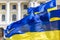 Ukraine independence concept picture of blue and yellow national flag evolving on a wind with main government building background