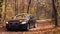 Ukraine. Kharkov 19 October 2019 Black Audi car driving on empty forest road over bright autumn leaves. Colorful fall