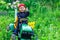 Ukraine Kiev 4 May 2019.A child on his little tractor John Deere .Portrait of young boy in nature, park or outdoors.Happy smiling