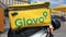 Ukraine, Kiev - August 29, 2020. Parked moped with yellow bag with Glovo logo near McDonald`s close-up. Courier service that