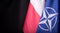 Ukraine, Kyiv - 10.04.2023. Official Flags of Poland and NATO against black Background. A Symbol of Unity and Resilience