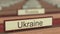 Ukraine name sign among different countries plaques at international organization. 3D rendering