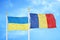 Ukraine and Romania two flags on flagpoles and blue sky