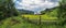 Ukraine rural countryside panorama. Wooden fence and house on Carpathian meadow