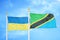 Ukraine and Tanzania two flags on flagpoles and blue sky