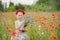 Ukrainian Beautiful girl in vyshivanka with wreath of flowers in a field of poppies and wheat. outdoor portrait in poppies. girl
