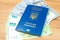 Ukrainian biometric passport id to travel the Europe with dollars and euros money on the table. Inscription in Ukrainian