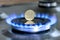 Ukrainian coin hryvnia on gas hob with burning natural gas