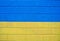 Ukrainian flag on a brick wall. Damaged wall in the colors of the flag. Blue-yellow wall