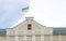 Ukrainian flag on the flagpole flies against a sky. Ukrainian flag on the building and a sign of the trident a symbol of Ukraine