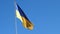Ukrainian flag waving in the wind and blue sky.